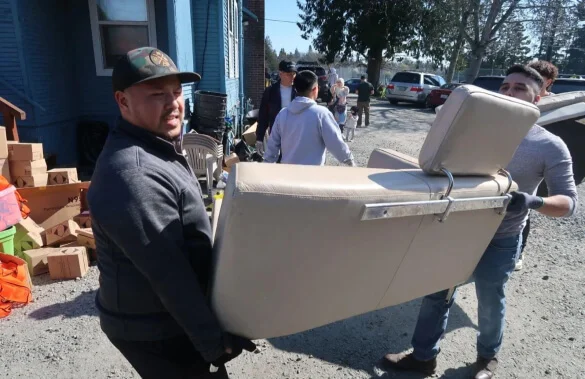 A man carrying a cooler down a street