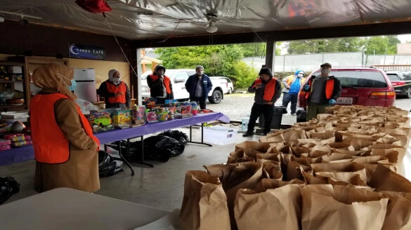 A group of people standing around a table filled with bags