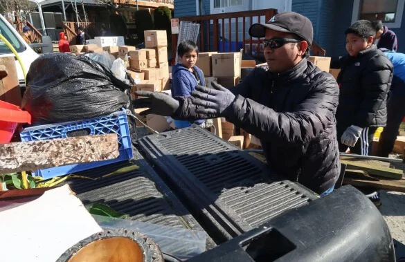 A man standing next to a pile of boxes